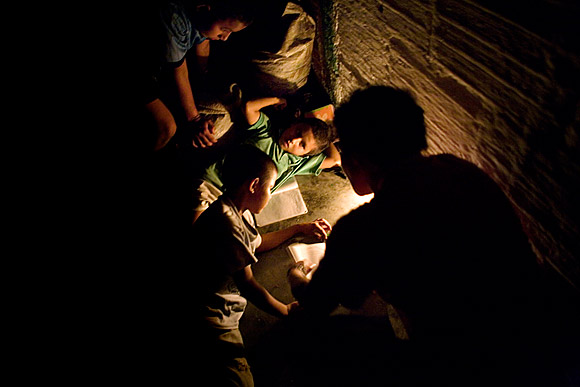 photograph of children studying by candlelight